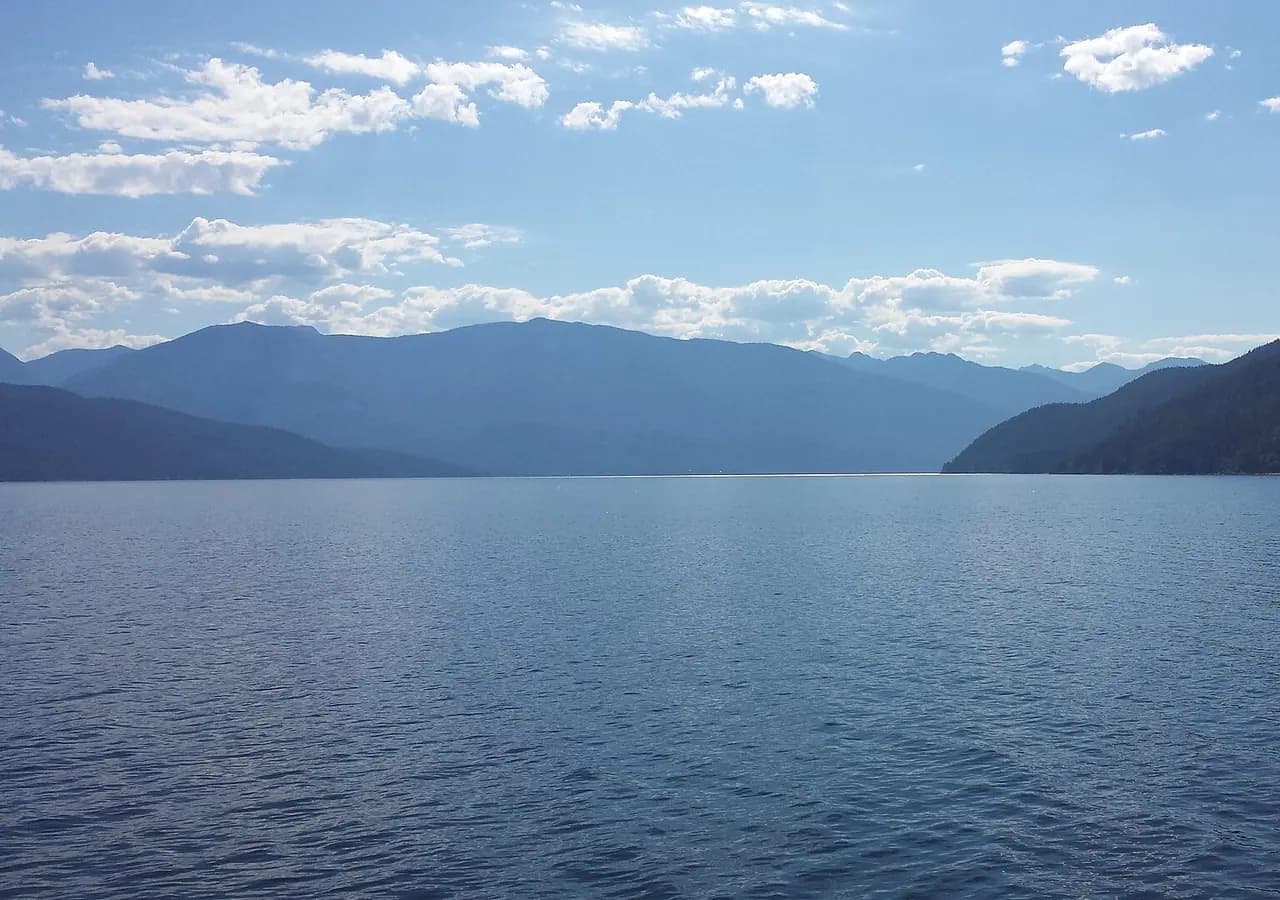 Kootenay Lake and surrounding mountains in British Columbia. Location context only; this is not a photograph of Yasodhara Ashram.