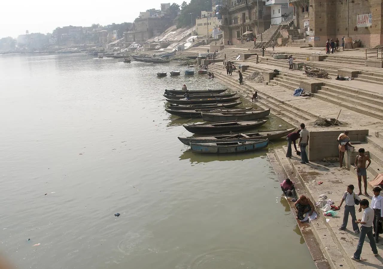 Historic riverside ghats and boats in Varanasi. Location context only; this is not a photograph of YSS Varanasi Meditation Centre.